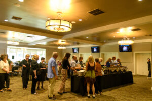 People lining up for a buffet table in a banquet room